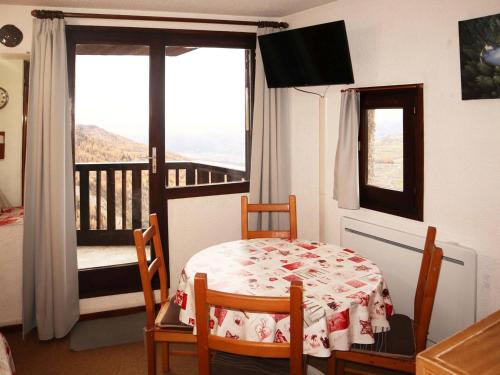 - une chambre avec une table et des chaises et un balcon dans l'établissement Studio confortable pour 4 au cœur des Orres, accès pistes - FR-1-322-53, aux Orres
