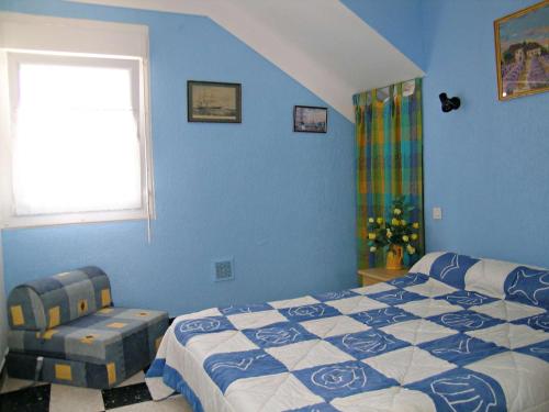une chambre avec des murs bleus et un lit et une fenêtre dans l'établissement Appartement T2 ensoleillé à 2 pas de la plage avec terrasse, parking et wifi options - FR-1-387-123, à Marseillan