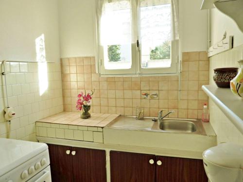 une cuisine avec un évier et une fenêtre dans l'établissement Appartement T2 ensoleillé à 2 pas de la plage avec terrasse, parking et wifi options - FR-1-387-123, à Marseillan