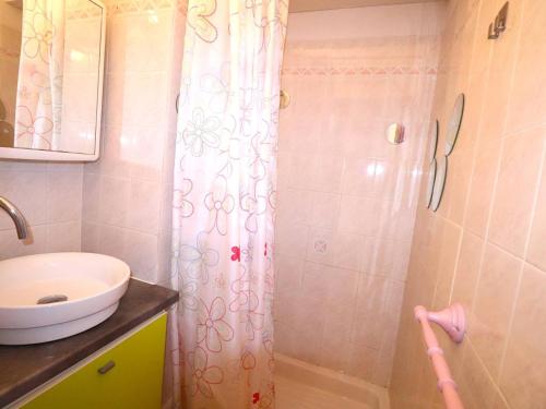 une salle de bain avec un rideau de douche et un lavabo dans l'établissement Appartement 2 Pièces Cabine avec Terrasse, Clim, Piscine et Proche Plage - 6 Couchages - FR-1-307-147, au Grau-du-Roi