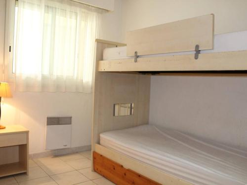 une chambre avec deux lits superposés et une fenêtre dans l'établissement Appartement 3 pièces avec piscine, proche plage et commerces - Villeneuve-Loubet, idéal pour 4 personnes - FR-1-252A-40, à Villeneuve-Loubet