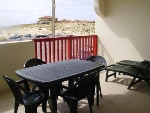 une table et des chaises noires sur un balcon avec vue dans l'établissement Appartement T2 avec terrasse et parking à Vieux-Boucau - FR-1-379-130, à Vieux-Boucau-les-Bains