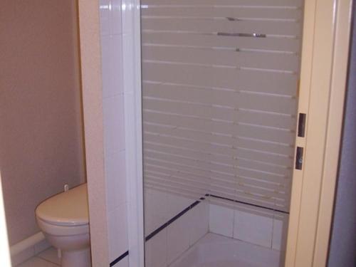 La salle de bains est pourvue de toilettes et d'une porte de douche en verre. dans l'établissement Appartement T2 avec terrasse et parking à Vieux-Boucau - FR-1-379-130, à Vieux-Boucau-les-Bains