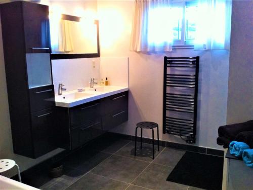 La salle de bains est pourvue d'un lavabo, d'un miroir et d'un tabouret. dans l'établissement Villa Moderne à Vagnas: Piscine Chauffée, 6 Pers, Proche Vallon Pont d’Arc - FR-1-382-176, à Vagnas