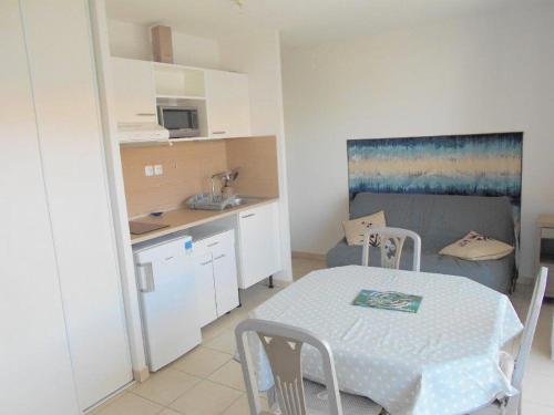 - une cuisine et une table dans une petite pièce dans l'établissement Appartement 2 pièces, terrasse, parking privé, proche plage et centre, Grau-du-Roi - FR-1-250-174, au Grau-du-Roi