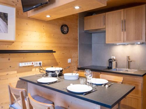 une cuisine avec un îlot doté d'une table et de chaises dans l'établissement Appartement rénové 22 m² - Val Thorens - 3 pers - Skis aux pieds - Confort & WiFi - FR-1-637-42, à Val Thorens