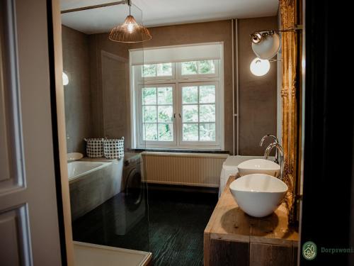 baño con lavabo, bañera y ventana en Modern Villa near Forest in Leende, en Schaft