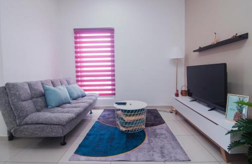 ein Wohnzimmer mit einem Sofa und einem Flachbild-TV in der Unterkunft Centrus Soho Cyberjaya by IdealHub in Cyberjaya