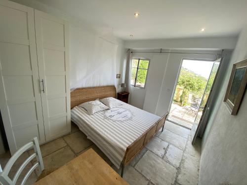 um pequeno quarto com uma cama e uma janela em Auberge de la Croix du Pape em Èze