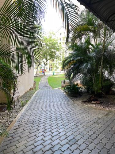 a cobblestone street with palm trees and a building at Zarahome in Tambun