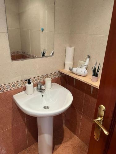 uma casa de banho com um lavatório e um espelho em Acogedor y soleado apartamento recién amueblado en Gijón em Gijón