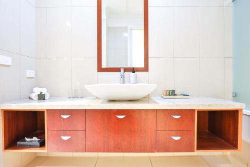a bathroom with a sink and a mirror at Indulge Apartments - Langtree in Mildura