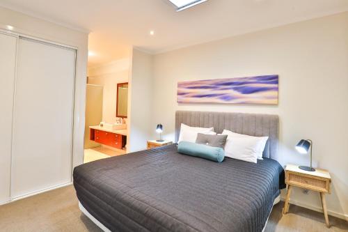 a bedroom with a bed with a blue pillow on it at Indulge Apartments - Langtree in Mildura