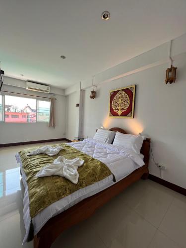 a bedroom with a bed with a robe on it at BB House Budget & Boutique in Chiang Mai