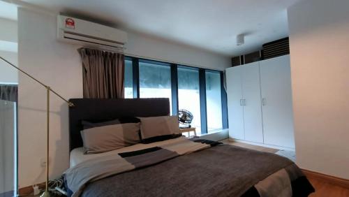 ein Schlafzimmer mit einem großen Bett und einem großen Fenster in der Unterkunft Signature LOFT EMPIRE CITY WIFI NETFLIX in Petaling Jaya