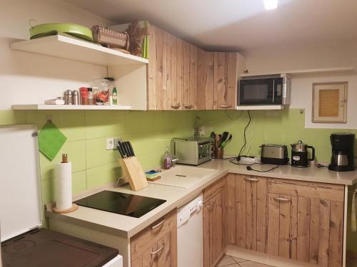una pequeña cocina con armarios de madera y microondas en Waldhaus St. Egidien, en Kurort Altenberg