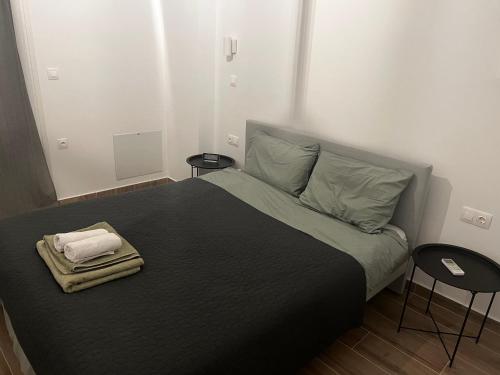 een slaapkamer met een groot bed en 2 tafels bij DISTRiCT 01 - Kalamaria in Thessaloniki