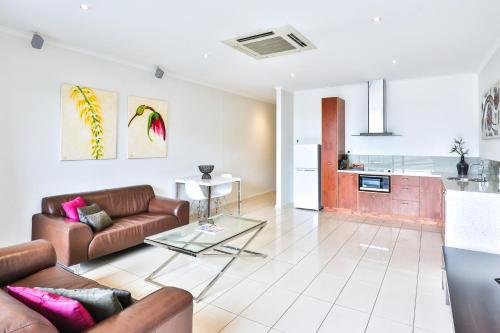 a living room with a couch and a table at Indulge Apartments - Langtree in Mildura
