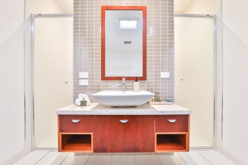 a bathroom with a sink and a mirror at Indulge Apartments - Langtree in Mildura