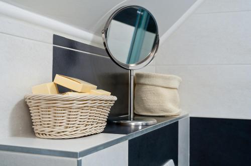a mirror and a basket on a shelf with a mirror at Hotel Berger in Kamenice nad Lipou