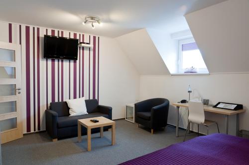 a room with a bed and a desk and a tv at Hotel Berger in Kamenice nad Lipou