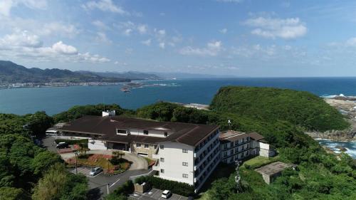 a building on a hill next to the ocean at Kobe Hotel Fruit Flower in Kobe