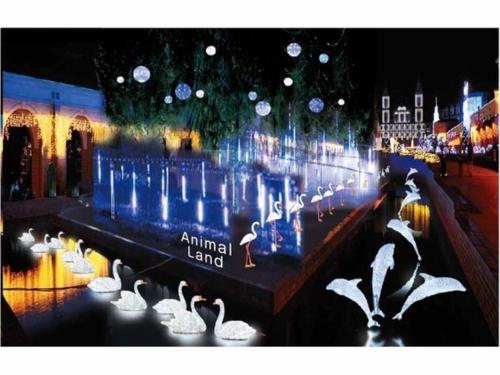 a group of white swans in a river with lights at Kobe Hotel Fruit Flower in Kobe