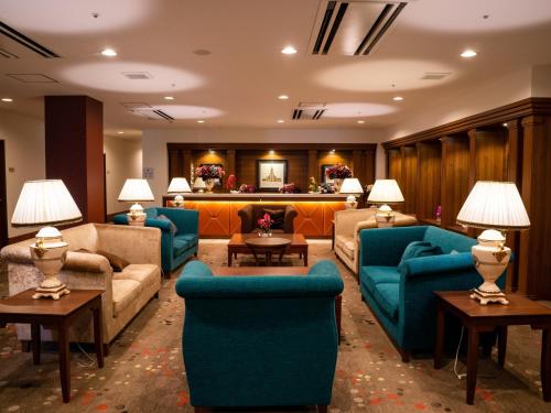a living room with blue couches and tables at Kobe Hotel Fruit Flower in Kobe