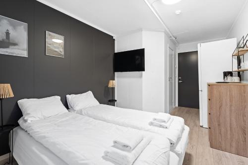 a bedroom with a large white bed with towels on it at Marina Hotel Lofoten in Svolvær
