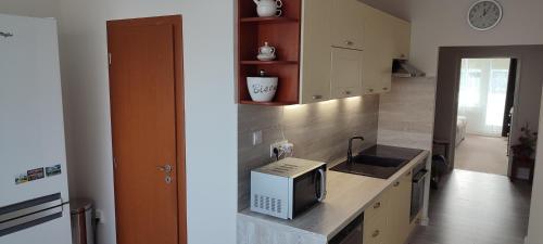 a kitchen with a sink and a microwave on a counter at Apartmán u Jána in Ružomberok