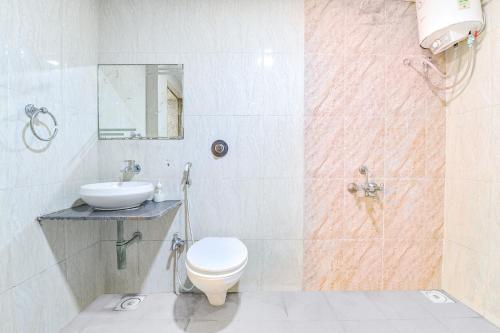 a bathroom with a toilet and a sink at FabHotel Skyland in Ahmedabad