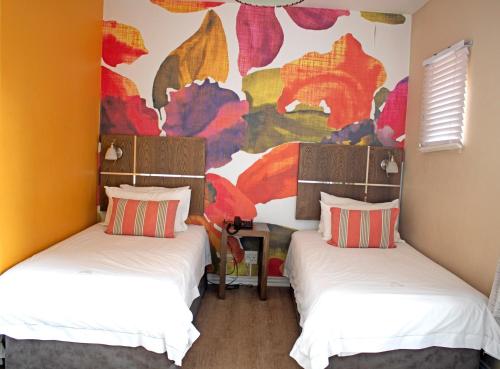 - 2 lits dans une chambre avec une fresque murale dans l'établissement 56 Oceanic Holiday Apartment, à Durban