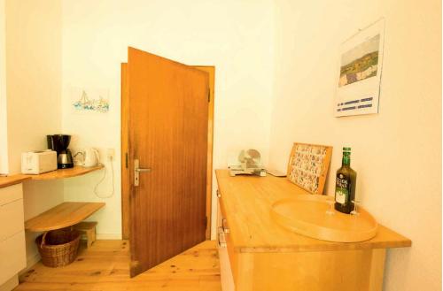 a bathroom with a sink and a bottle of wine at Jagdhaus am Bach in Losheim