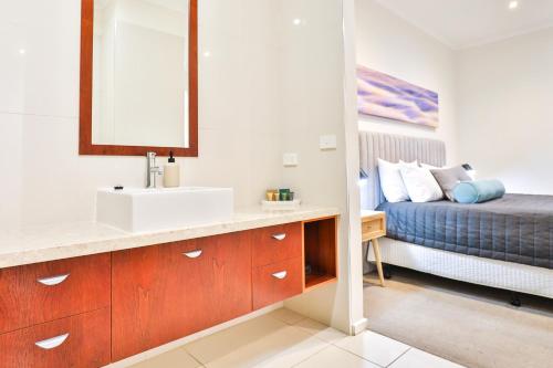 a bathroom with a sink and a bed at Indulge Apartments - Langtree in Mildura