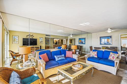 a living room with a blue couch and chairs at Holiday Surf & Racquet 614 Condo in Destin