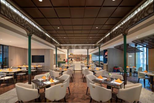 a rendering of a restaurant with tables and chairs at Voco Chongqing Chaotianmen in Chongqing