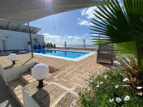 a swimming pool with a view of the ocean at LES OLIVIERS in Oualidia