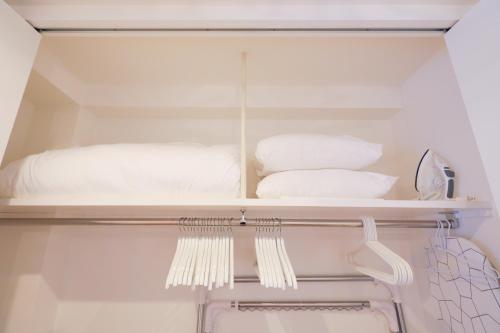 un armario con algunas toallas blancas en un estante en Space Roppongi, en Tokio