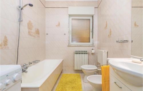 La salle de bains est pourvue d'une baignoire, de toilettes et d'un lavabo. dans l'établissement Nice Apartment In Lovran With Kitchen, à Lovran