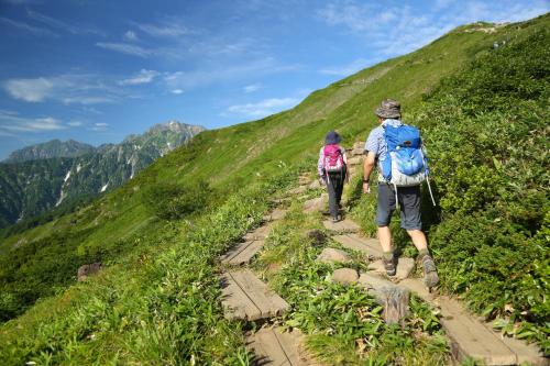 two people walking down a trail on a mountain at Square 8 HAKUBA RETREAT by UNPLAN in Hakuba