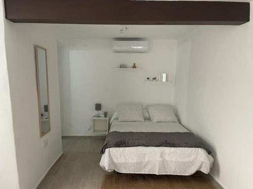 een slaapkamer met een bed in een witte muur bij La Faraona in Jerez de la Frontera