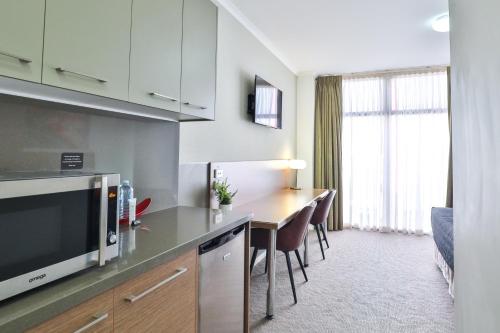 a kitchen with a table and chairs in a room at Indulge Apartments - Ontario in Mildura