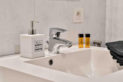 - un lavabo avec un robinet et un distributeur de savon dans l'établissement Interbellum, à Ypres