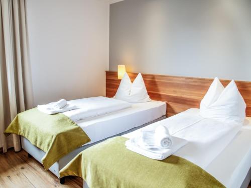two beds in a hotel room with towels on them at Berghotel Malta in Malta