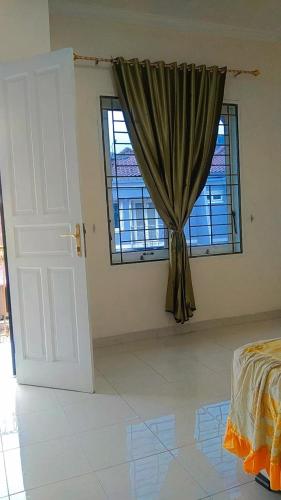 a bedroom with a bed and a window with a curtain at Villa MountView No 88 Berastagi View in Berastagi