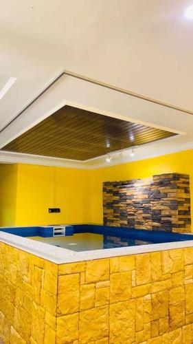 cocina con paredes amarillas y encimera en Irama Studio with Indoor Private Pool, en Kota Bharu