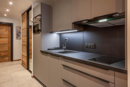 une cuisine avec un évier et une cuisinière dans l'établissement Chevruls A9, à Morzine