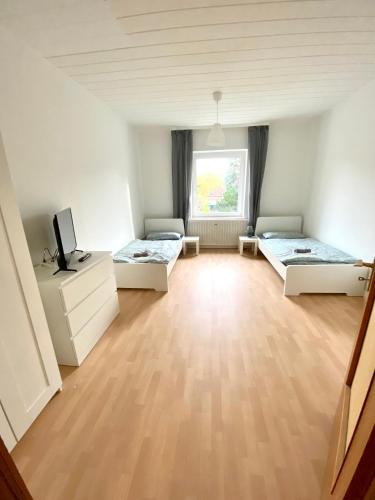 um quarto com duas camas e uma televisão em Core Rooms - Apartment Oberhausen em Oberhausen