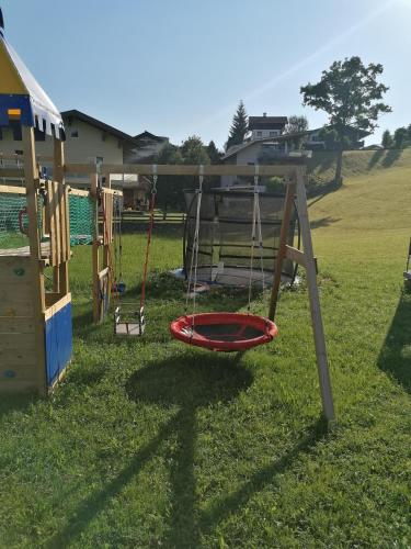 a playground with a swing in the grass at Appartment Martin in Westendorf