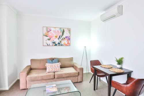 a living room with a couch and a table at Indulge Apartments - Ontario in Mildura
